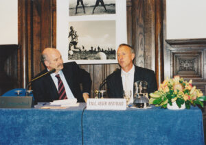 'Rob Siekmann en Johan Cruijff tijdens een bijeenkomst over sport en ontwikkelingssamenwerking in 2002 in Den Haag.'